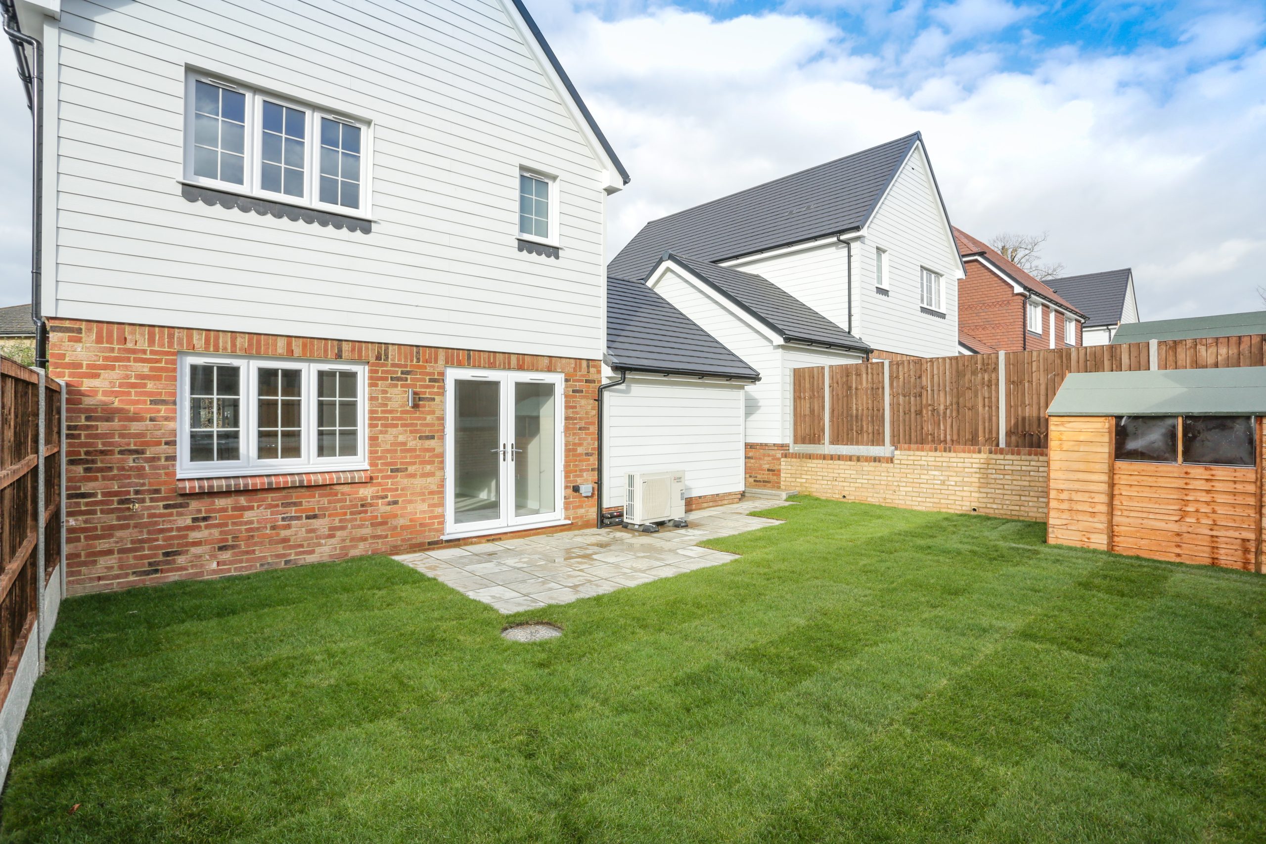 Rear garden with laid patio and lawn complete with shed at Ivy court