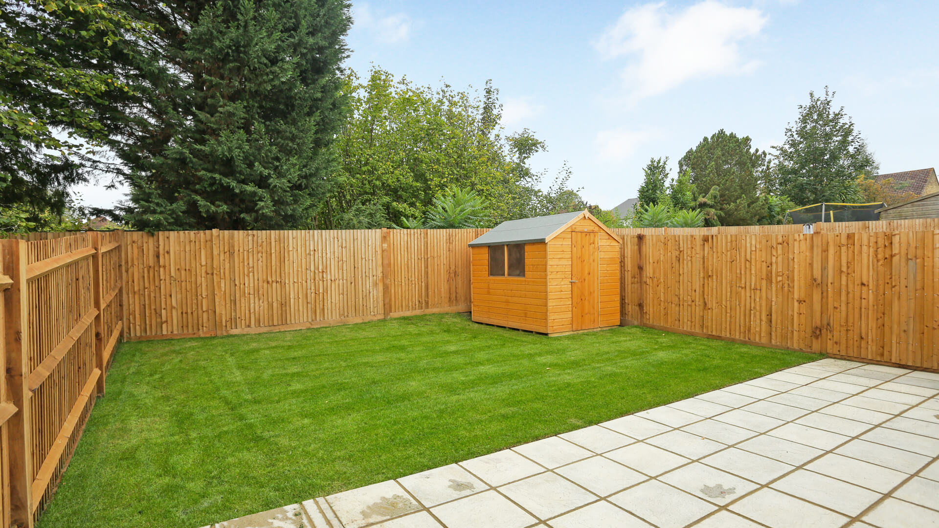 Rear garden with patio and lawn complete with shed