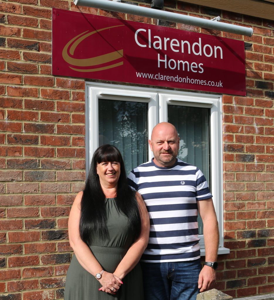 Julia and Krzysztof standing in front of the Clarendon Homes office